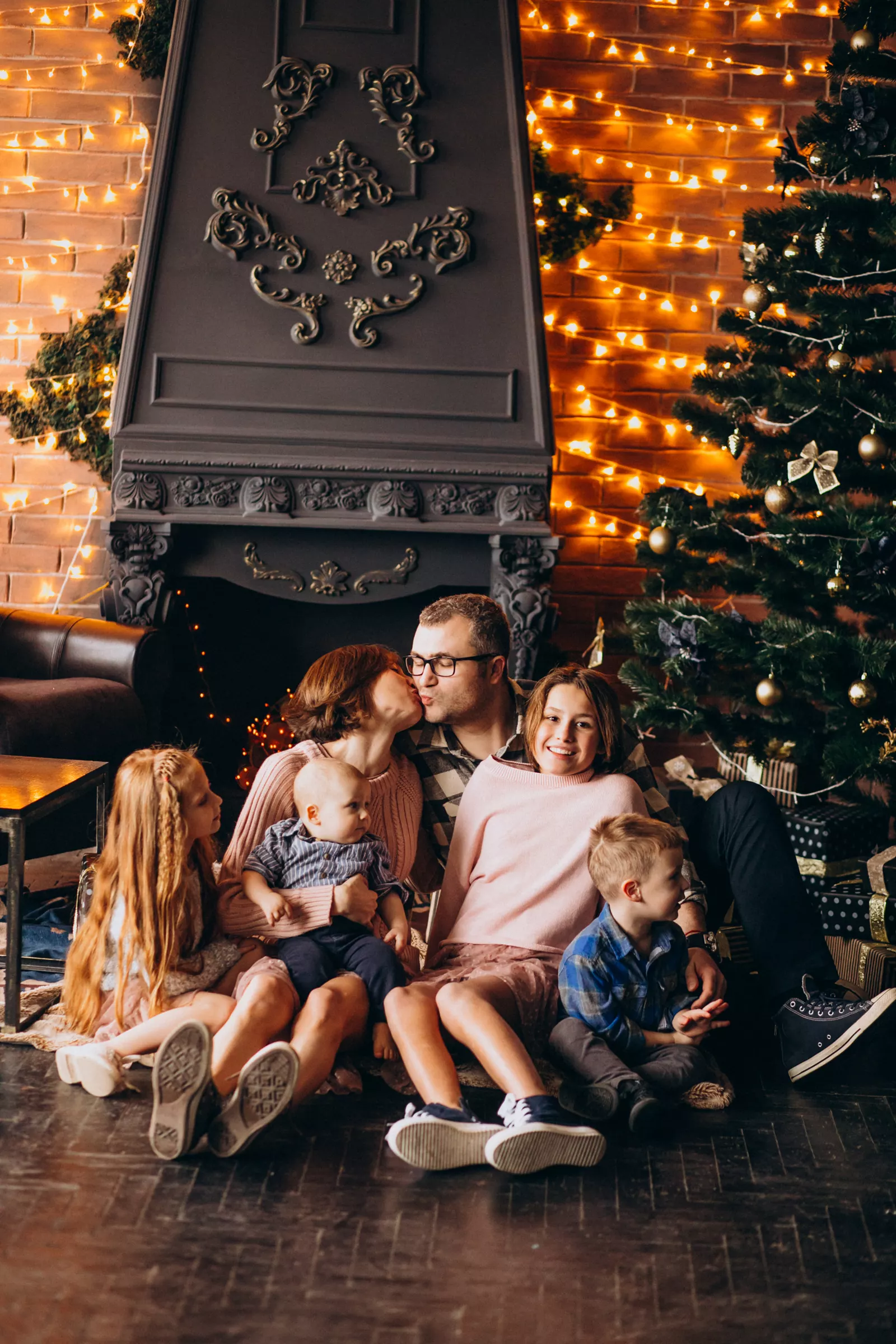 Multi-generation family gathered by the Christmas tree exchanging presents on Christmas Eve