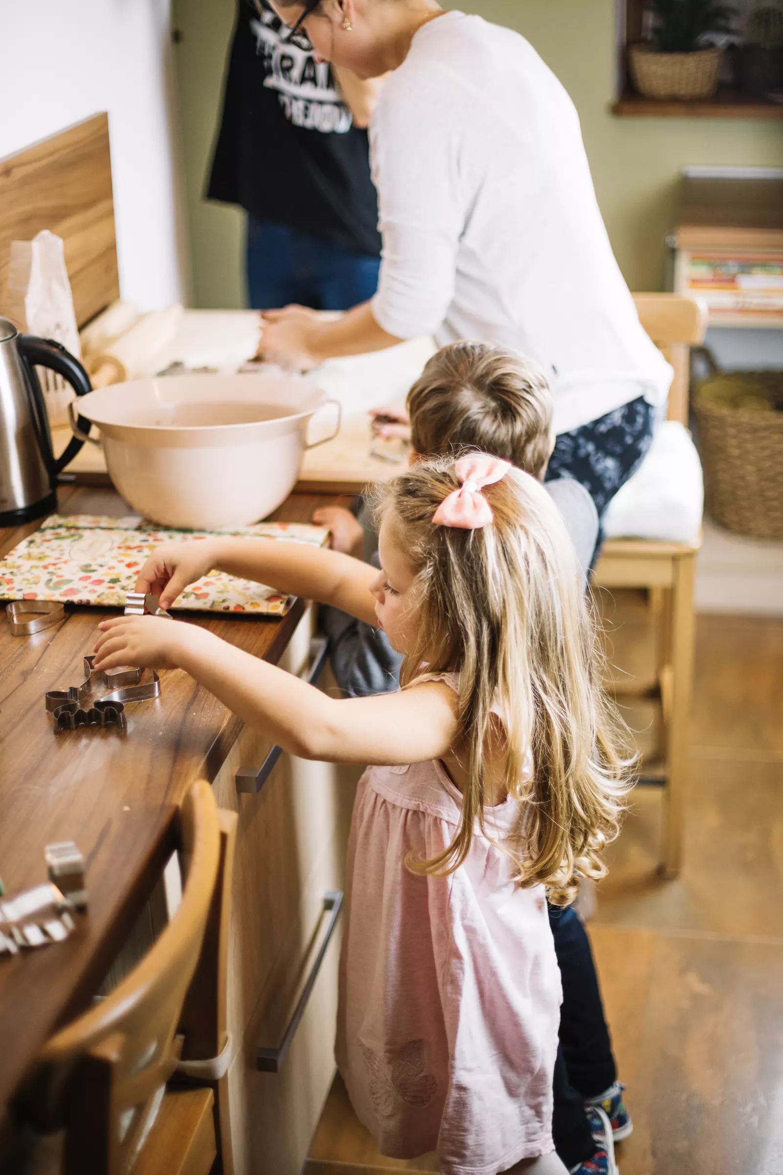 Kids decorating gingerbread cookies at a flour-dusted holiday table